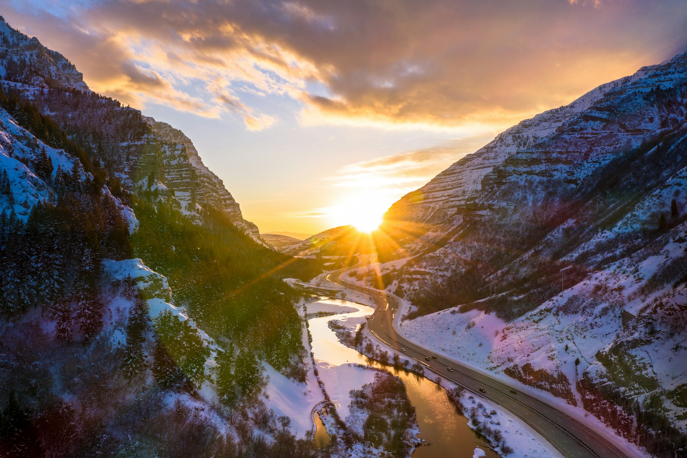 Illustrative aerial view of a snowy canyon and river at sunset